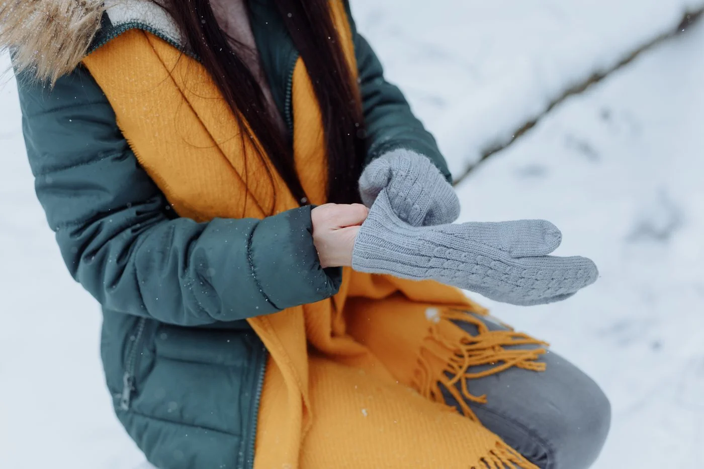 A person putting on knitted winter mittens