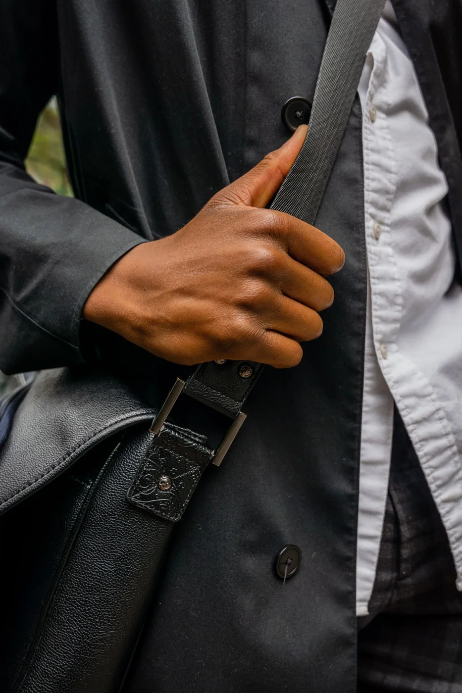 Photo of a Person's Hand Holding the Strap of a Bag