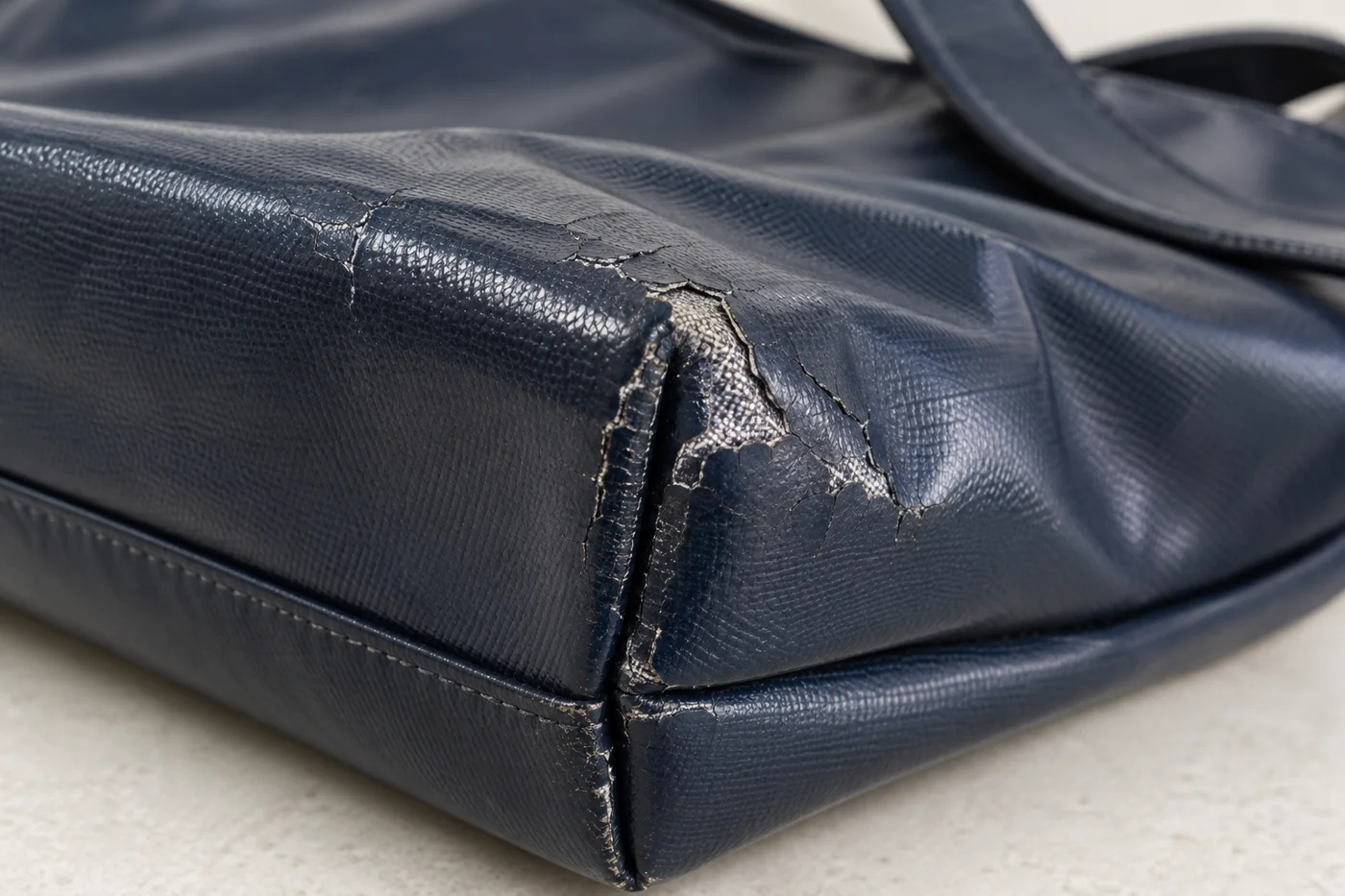 Close-up of worn coating over a fabric bag surface